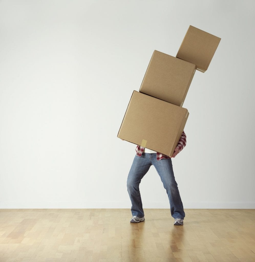 Man carrying a stack of moving boxes stacked above his head