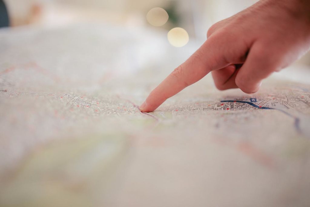Finger pointing to paper map