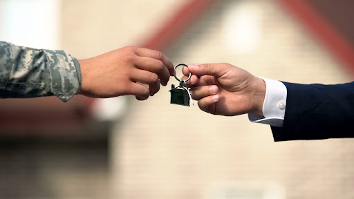 Man in business suit handing over keys to a rented military house in Colorado Springs