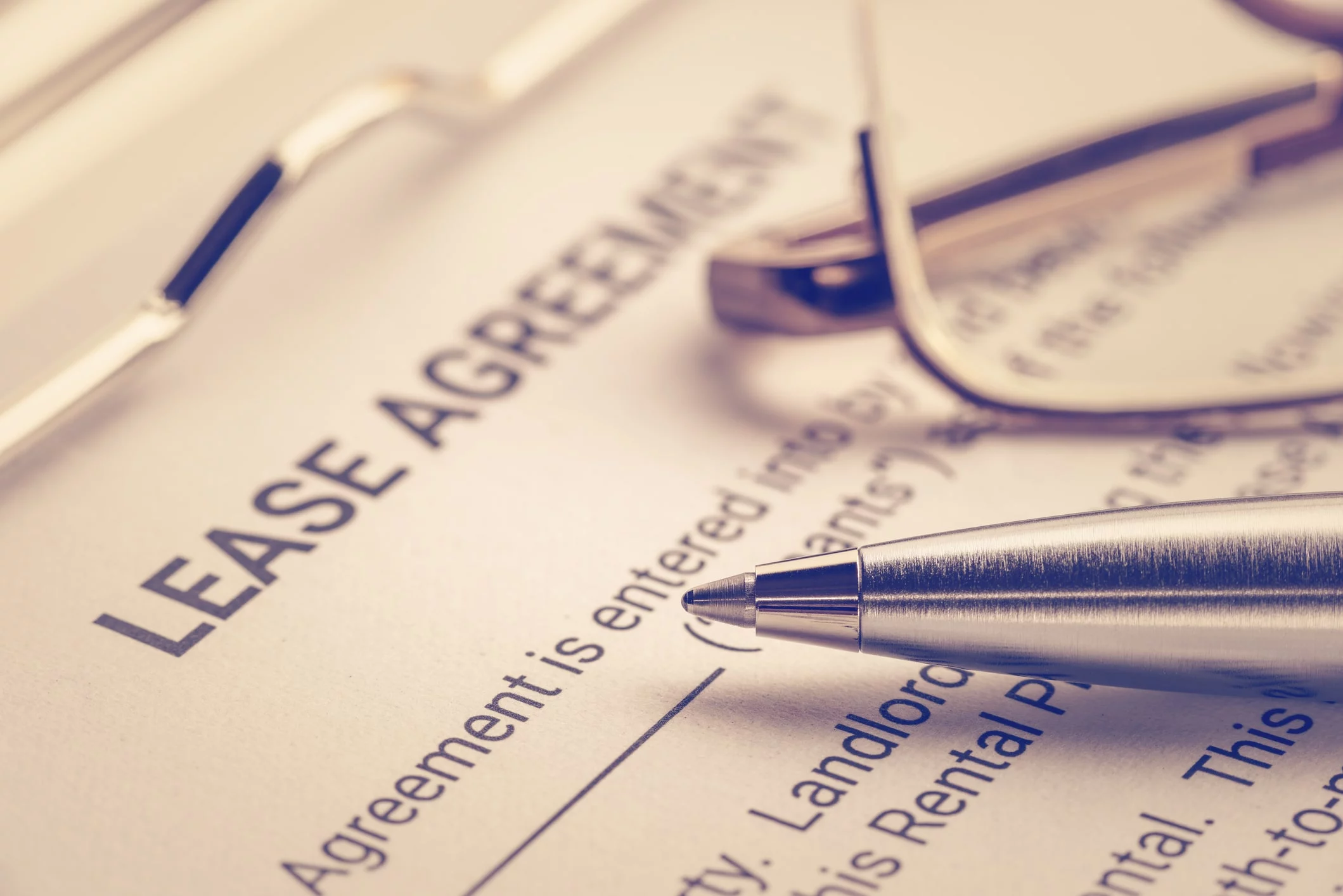 Pen and pair of eye glasses sitting on a lease agreement form